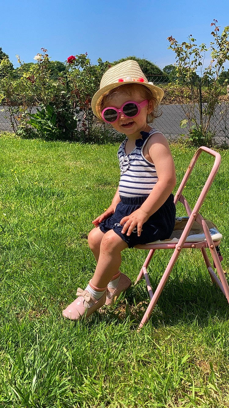 Lizea participe au concours pour gagner de l'argent avec cette photo : botany, chair, eyewear, folding_chair, goggles, grass, grassland, hat, leaf, leisure, people_in_nature, person, plant, shorts, sky, smile, summer, sun_hat, sunglasses, tree