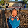 Miles joined the competition — help win amazing prizes! child, toddler, swing, playground, smile, happy, outdoor, park, swing_seat, chains, wood_chips, sunlight, shadow, building, trash_can, trees, sky, jeans, hands, portrait