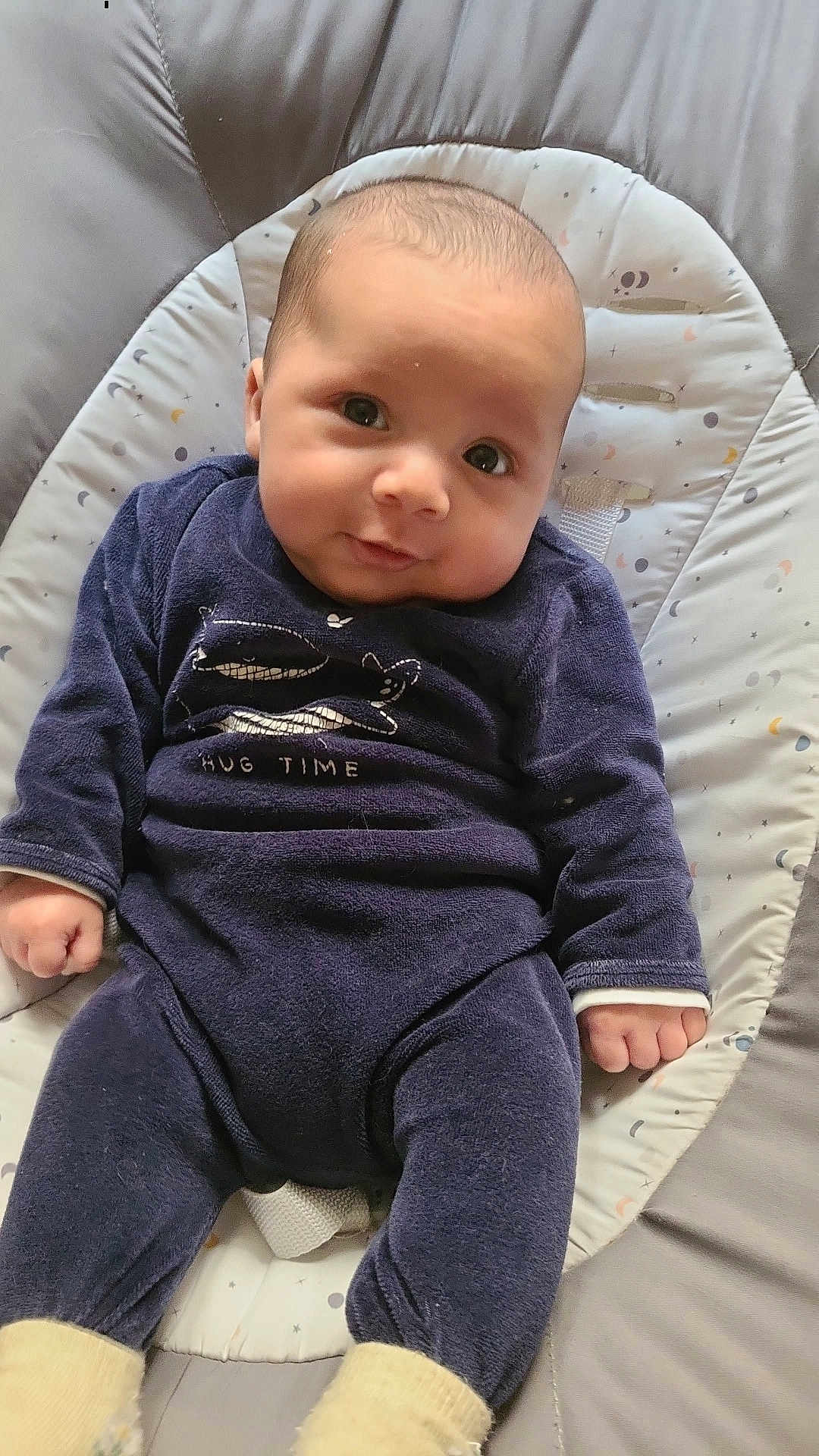 Gabriel participe au concours pour gagner de l'argent avec cette photo : baby, infant, child, clothing, onesie, seat, baby_seat, pattern, smile, face, eyes, hand, footwear, socks, comfort, indoor, portrait, cute, young, relaxing