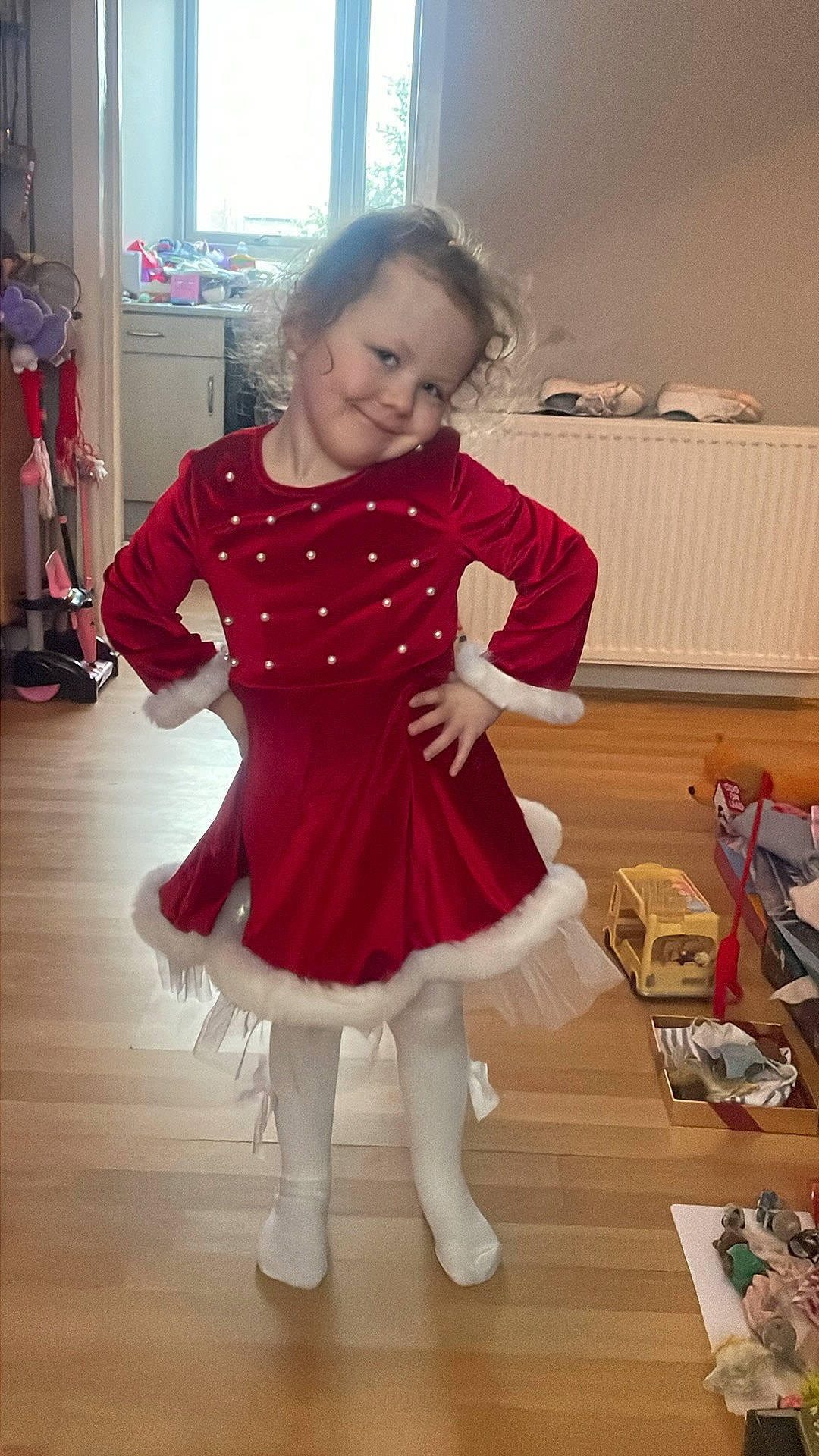 Brooklyn is registered to the contest to win money with this photo: baby_toddler_clothing, door, dress, event, fashion_design, floor, flooring, happy, hardwood, human_leg, joint, joy, magenta, one_piece_garment, person, shoulder, sleeve, smile, sock, toddler