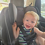 Tripp is registered to the contest to win money with this photo: toddler, child, car_seat, safety_1st, smiling, happy, curly_hair, blonde, blue_eyes, striped_shirt, seat_belt, car_interior, window, daylight, sitting, baby, infant, cute, person, young_child