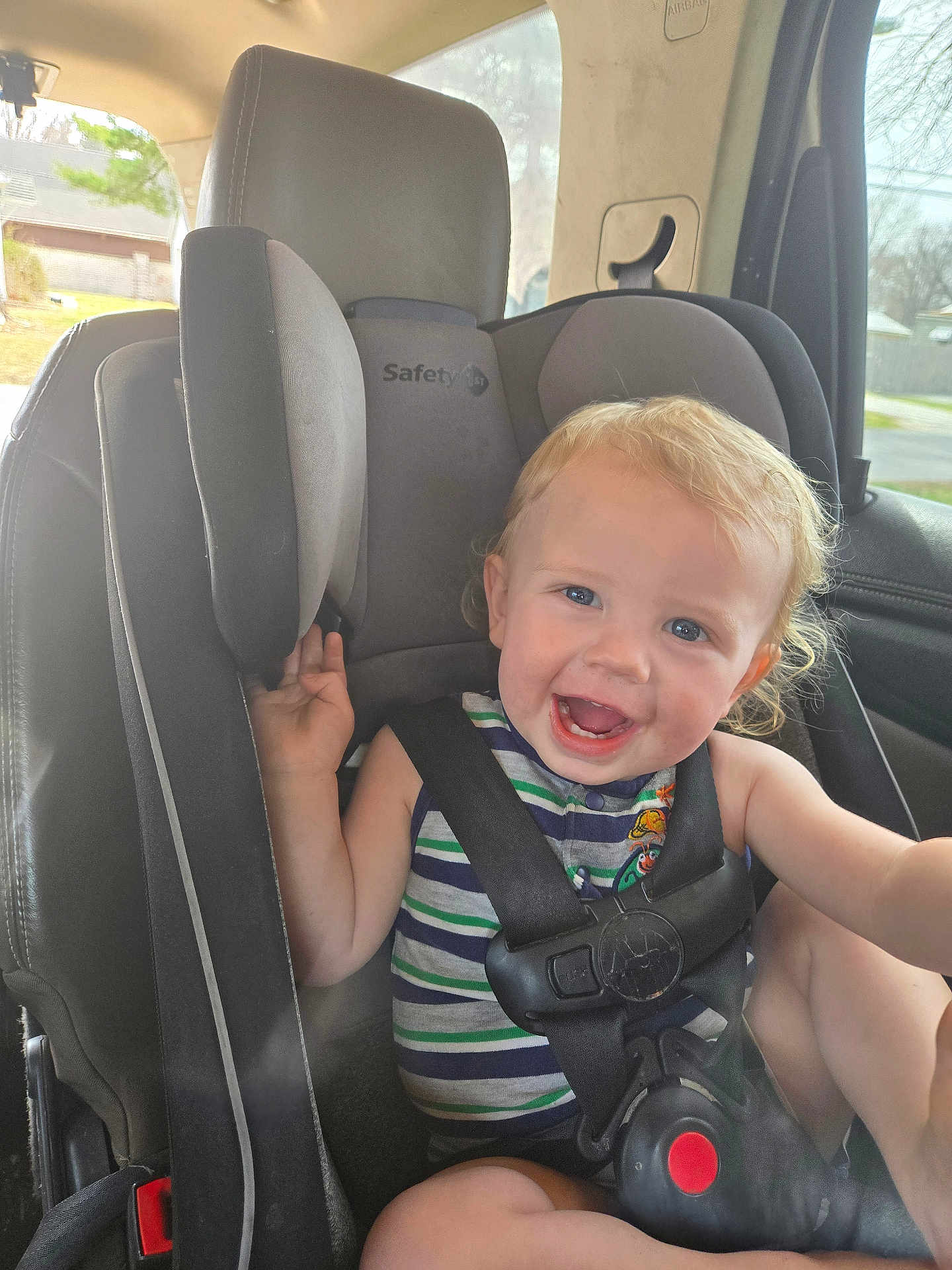 Tripp is registered to the contest to win money with this photo: toddler, child, car_seat, safety_1st, smiling, happy, curly_hair, blonde, blue_eyes, striped_shirt, seat_belt, car_interior, window, daylight, sitting, baby, infant, cute, person, young_child