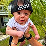 baby, child, infant, cap, hat, black_cap, white_shirt, outdoor, greenery, palm_leaves, hands, person, grass, house, smiling, cute, portrait, young_child, playing, nature