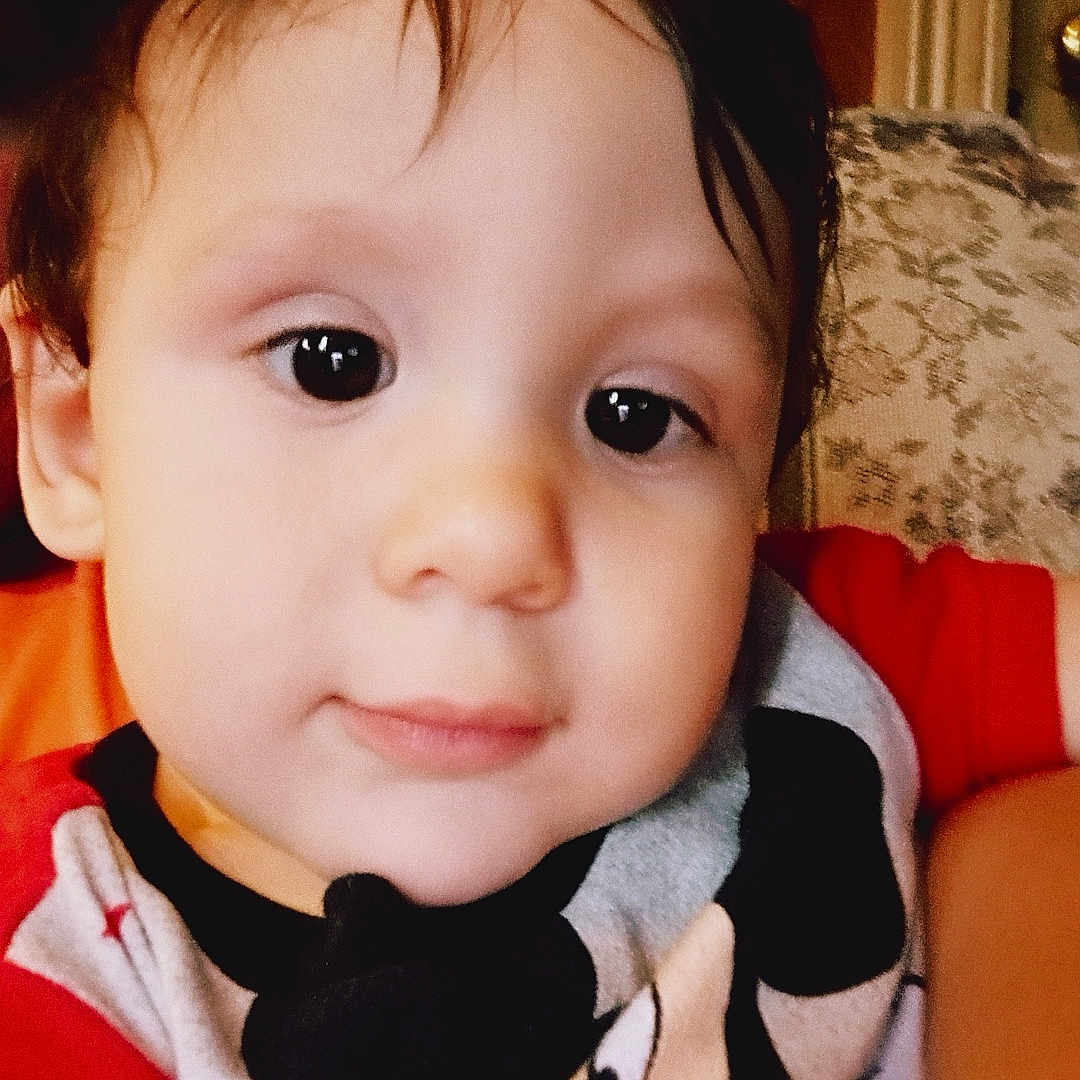 Kolton joined the competition — help win amazing prizes! background, child, closeup, clothing, couch, curly_hair, cute, eyes, face, happy, indoor, mickey_mouse, pattern, person, portrait, shirt, smile, toddler, wood, young