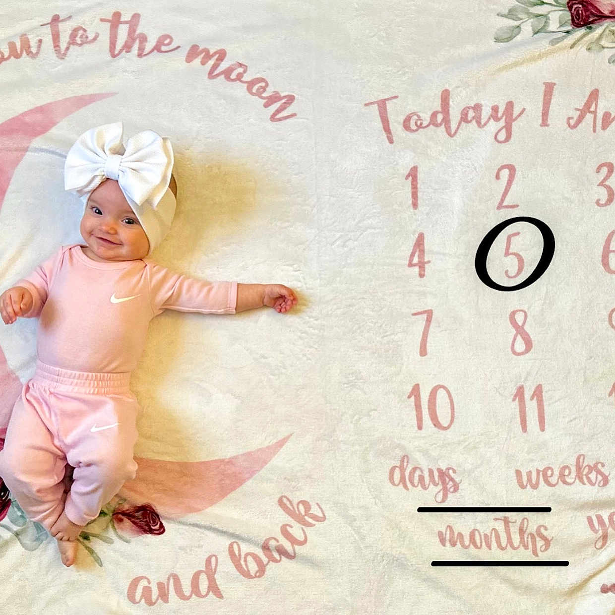 Raelynn is registered to the contest to win money with this photo: baby, bonnet, clothing, face, flower, flowerarrangement, flowerbouquet, hat, head, newborn, number, person, petal, photography, plant, portrait, rose, sitting, symbol, text