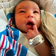 Serenity is registered to the contest to win money with this photo: newborn, baby, infant, face, portrait, sleepy, awake, yawning, thumb, hand, hospital, wristband, blanket, swaddled, striped, colorful, cuddled, close_up, indoors, bed