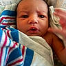 Serenity is registered to the contest to win money with this photo: newborn, baby, infant, child, face, portrait, wide_eyes, looking_at_camera, blanket, swaddled, striped_blanket, blue, pink, white, indoors, close_up, head, eyes, nose, mouth