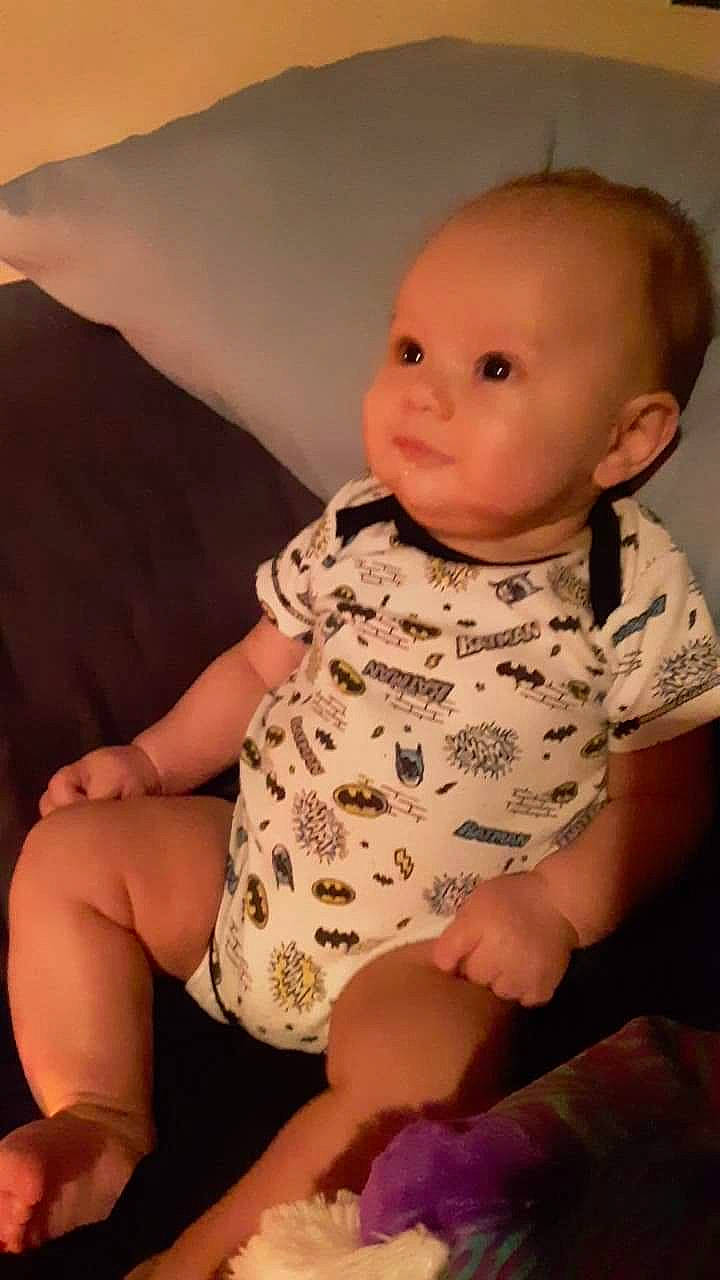 Cayde is registered to the contest to win money with this photo: arm, cheek, child, eye, face, finger, girl, hand, head, human_hair_color, infant, iris, mouth, person, pink, product, sitting, skin, smile, textile