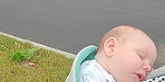 Hunter is registered to the contest to win money with this photo: baby, carrier, child, comfort, grass, infant, nap, nature, outdoor, parked_cars, peaceful, person, quiet, residential_area, road, sidewalk, sleeping, striped_clothing, trees, young