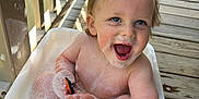 Adrian joined the competition — help win amazing prizes! toddler, child, bath, bubbles, soap, toy_car, smile, happy, water, foam, outdoor, porch, wooden_floor, sunlight, play, cute, face, hands, skin, hair