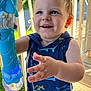 blue_eyes, bubble_wand, bubbles, child, closeup, cute, daylight, face, hand, happy, outdoor, playful, porch, shark_pattern, sleeveless_shirt, smiling, summer, sunlight, toddler, toy