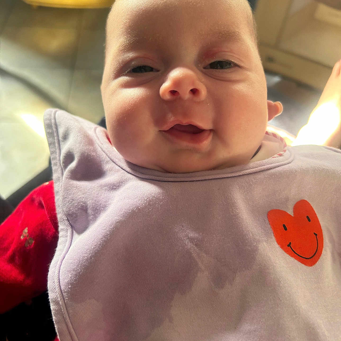 Talya participe au concours pour gagner de l'argent avec cette photo : baby, baby_bib, bib, child, closeup, clothing, cute, expression, face, happy, heart, indoor, infant, person, portrait, red_clothing, smile, sunlight, warm_light, young_child