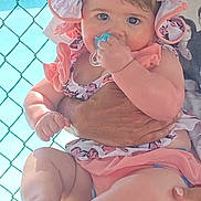 Araya Hope is registered to the contest to win money with this photo: baby, child, pacifier, pink_clothing, sunhat, adult, holding, outdoor, pool, fence, curious, cute, skin, face, person, summer, daylight, tattoo, legs, hands