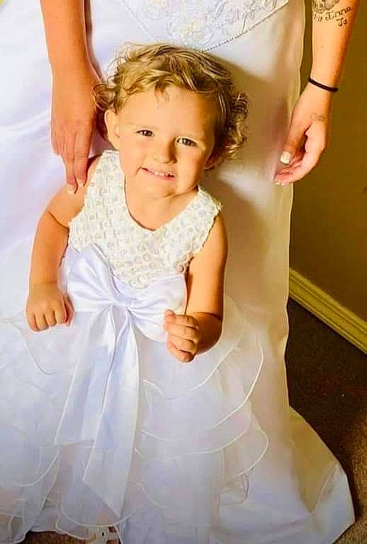 Emma Jo is registered to the contest to win money with this photo: baby_toddler_clothing, bridal_accessory, bridal_clothing, bridal_party_dress, day_dress, dress, finger, flash_photography, gesture, gown, happy, joy, one_piece_garment, person, pink, shoulder, skin, sleeve, smile, toddler