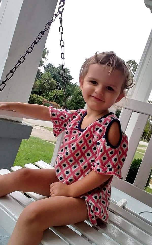 Emma Jo is registered to the contest to win money with this photo: baby_toddler_clothing, black, boat, dress, face, facial_expression, finger, hairstyle, happy, head, joy, leg, leisure, person, photograph, pink, skin, sky, smile, summer