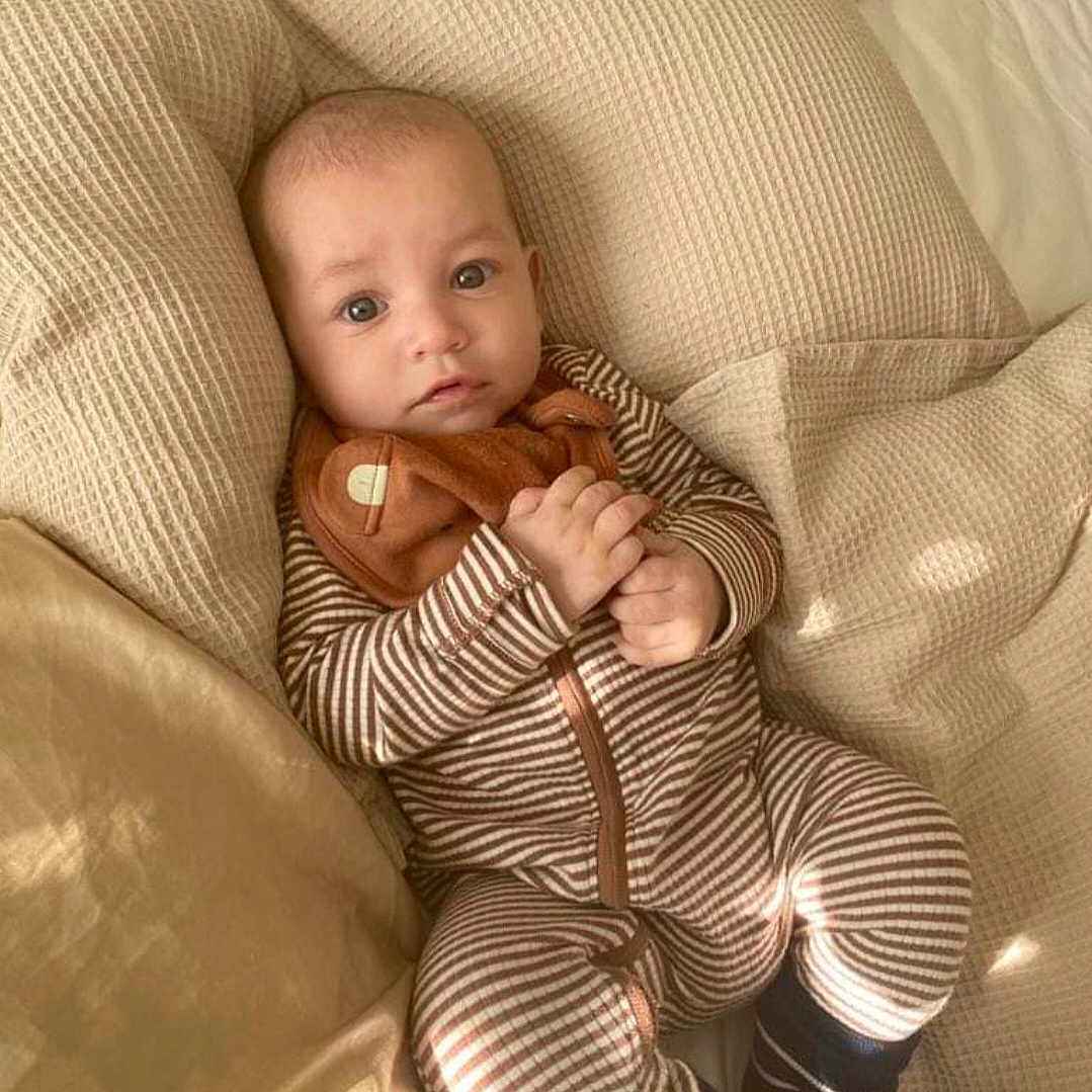 Vinnie-Daniel is registered to the contest to win money with this photo: baby, blanket, bodypart, clothing, couch, cushion, face, finger, footwear, furniture, hand, head, homedecor, pants, person, photography, portrait, quilt, shoe, sitting