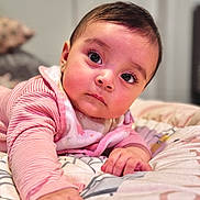 Ainnara is registered to the contest to win money with this photo: baby, infant, child, face, hands, blanket, pink_clothing, portrait, cute, lying_down, indoors, soft_lighting, curious, closeup, person, newborn, toddler, warm_colors, sleepwear, expression