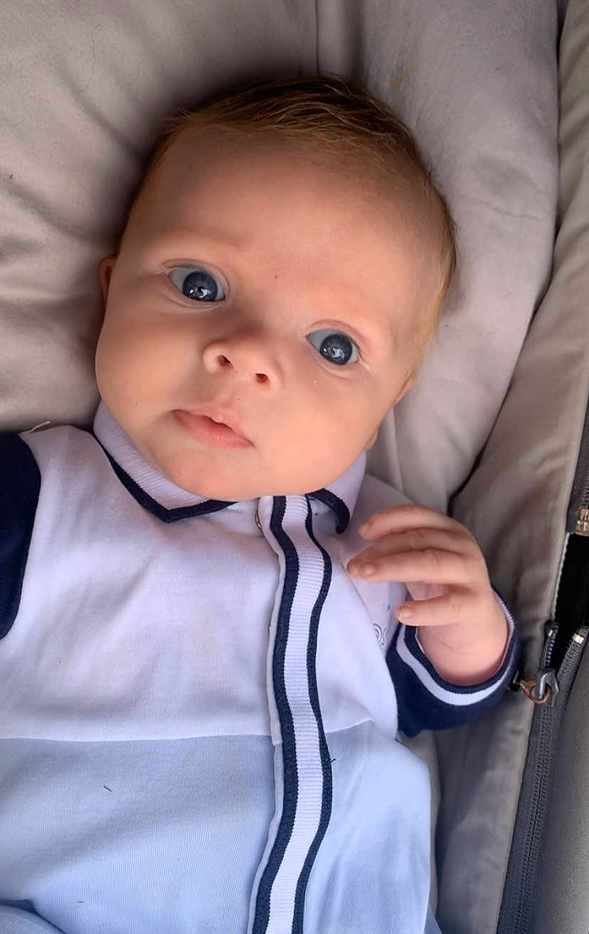 Ollie joined the competition — help win amazing prizes! baby, infant, face, blue_eyes, clothing, white, navy, striped, hand, soft, cushion, closeup, portrait, young_child, curious, cute, child, apparel, fabric, indoor
