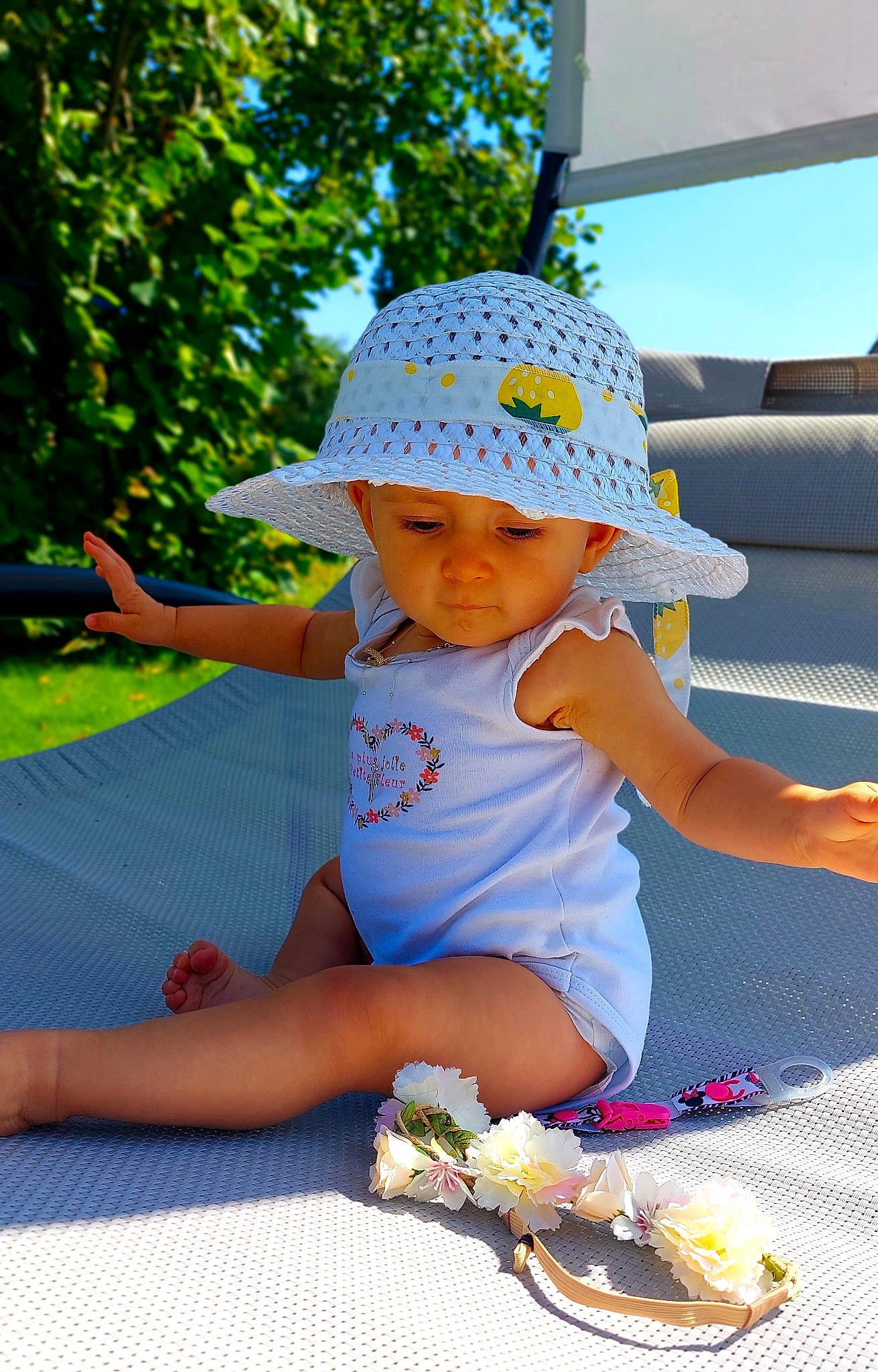 Molly participe au concours pour gagner de l'argent avec cette photo : baby_toddler_clothing, baseball_cap, cap, child, electric_blue, fun, grass, happy, hat, headwear, human_leg, leisure, person, plant, recreation, shorts, sitting, summer, sun_hat, toddler