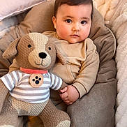 Vicente a rejoint le concours — aidez-le/la à gagner de superbes lots ! baby, child, plush_toy, knitted_dog, cushion, blanket, pillow, soft_toys, cute, indoors, childhood, portrait, infant, smiling, warm, cozy, baby_clothing, hand, face, sitting