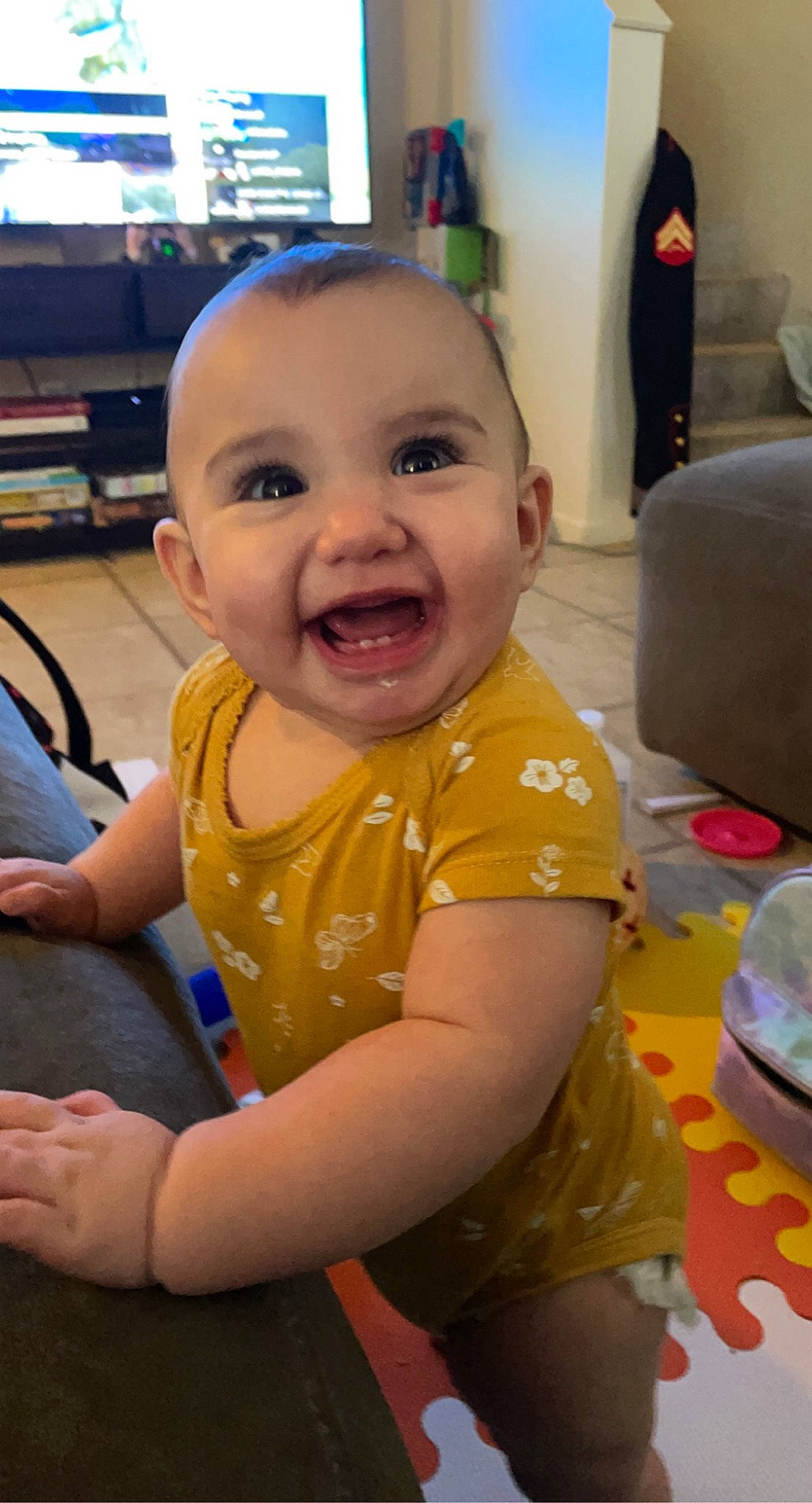 Aqua is registered to the contest to win money with this photo: baby, baby_toddler_clothing, cheek, child, eye, facial_expression, floor, flooring, fun, happy, head, human_body, iris, mouth, nose, person, sitting, skin, smile, thumb