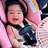 baby, infant, car_seat, pink, smiling, happy, face, hair, mittens, clothing, safety_harness, seatbelt, fan, white_outfit, cute, child, indoors, comfort, joy, portrait