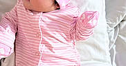 Amara Adame joined the competition — help win amazing prizes! baby, infant, pink, hat, striped_clothing, heart_pattern, cute, lying_down, cushion, soft, sleepwear, child, newborn, portrait, indoors, apparel, person, face, cozy, resting