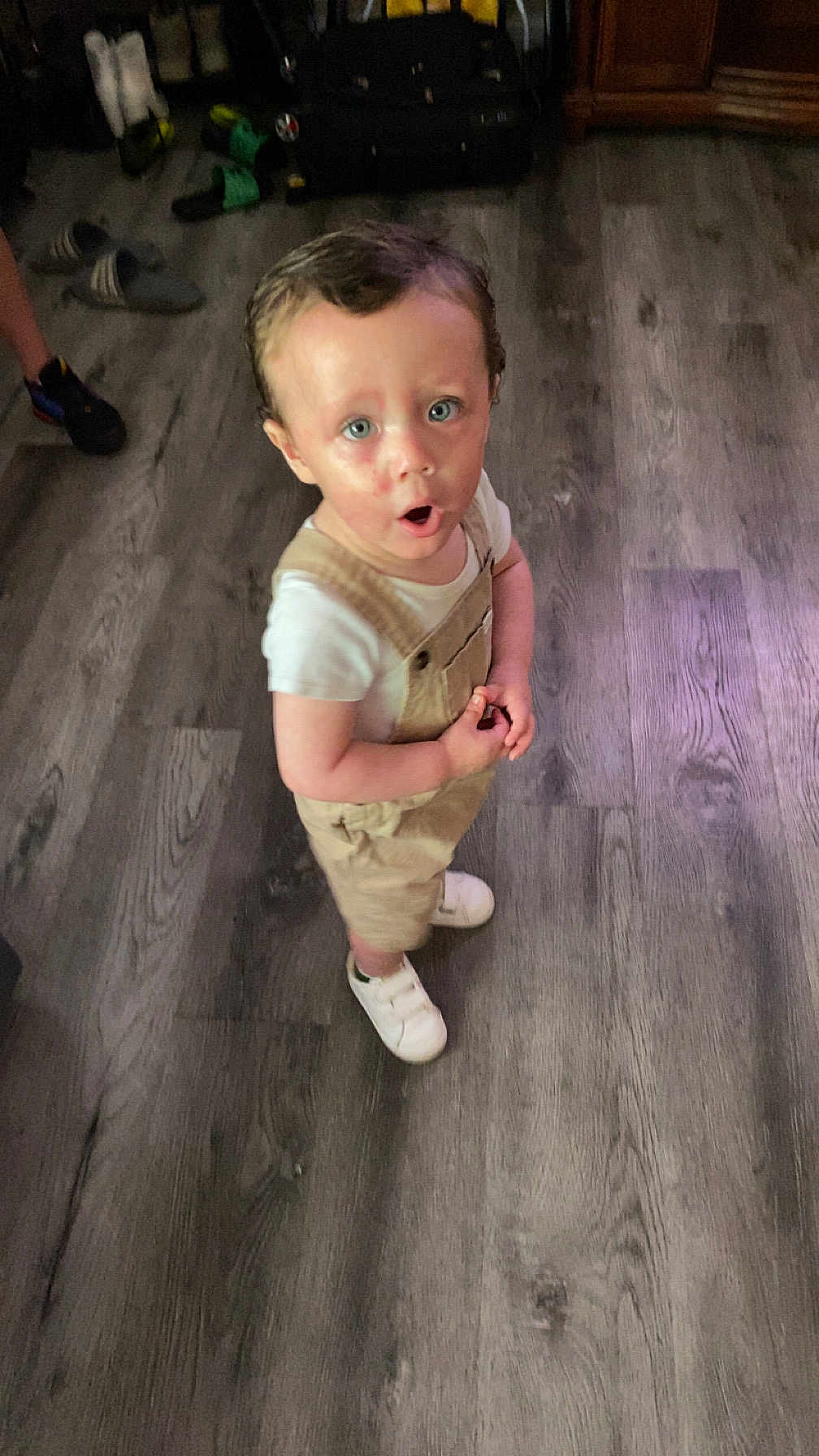 Luca joined the competition — help win amazing prizes! toddler, child, indoor, flooring, wood_floor, overalls, white_shirt, white_shoes, expression, surprised, standing, person, blue_eyes, hair, light, casual_clothing, home, footwear, young_child, cute