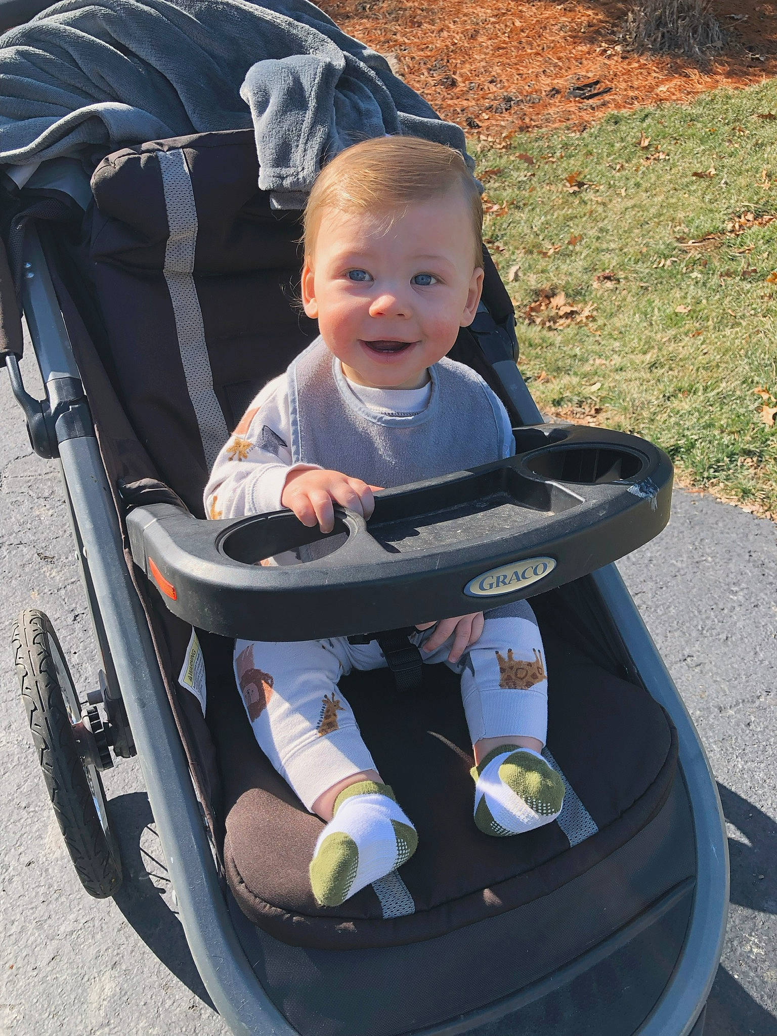 Beckham is registered to the contest to win money with this photo: auto_part, baby, baby_carriage, baby_products, baby_safety, baby_toddler_clothing, child, cleanliness, comfort, electric_blue, fun, grass, happy, joy, lap, person, sitting, smile, tire, toddler