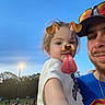 Blaire is registered to the contest to win money with this photo: child, man, selfie, dog_filter, face_filter, outdoor, evening, sky, people, park, casual, fun, smile, glasses, hat, pointing, hand, clothing, light, nature