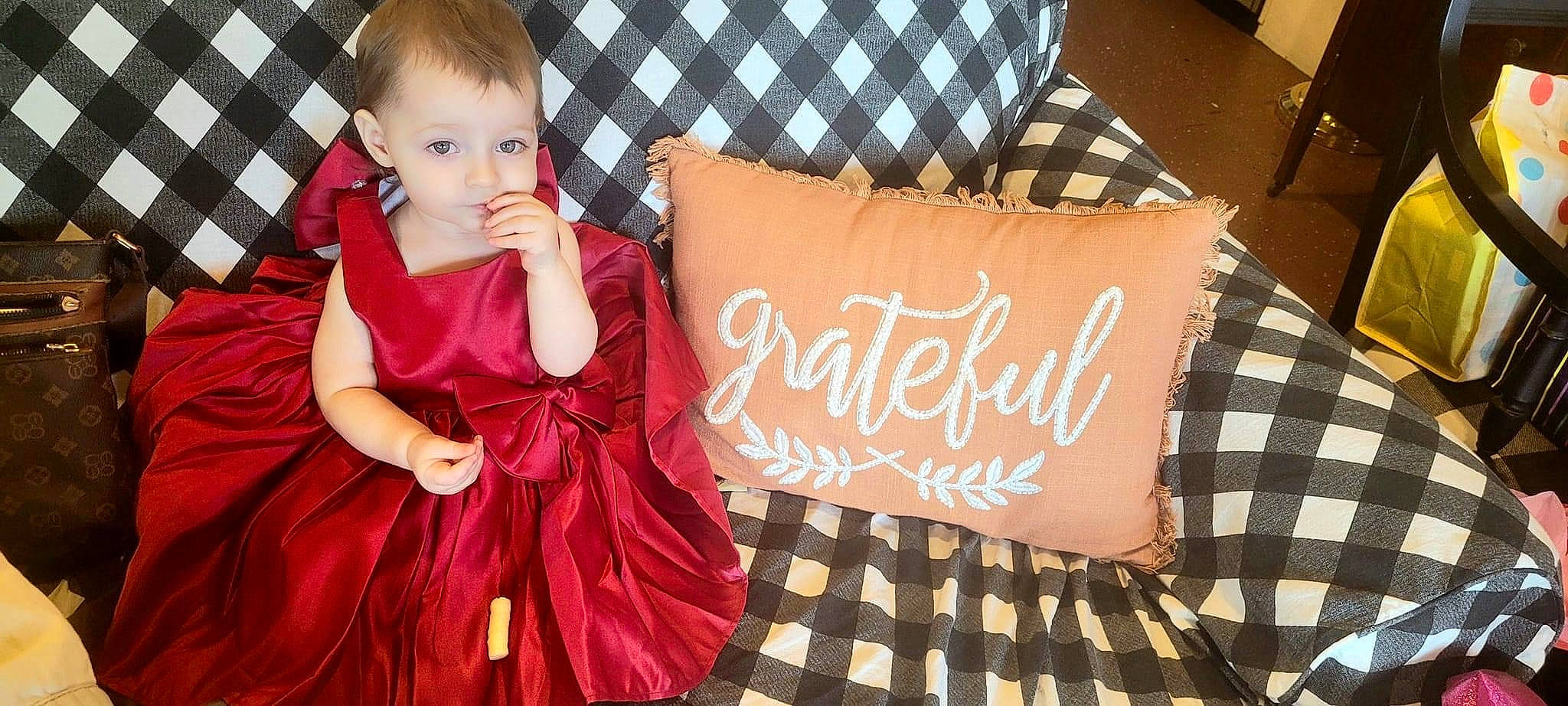 Emberlynn is registered to the contest to win money with this photo: baby_toddler_clothing, bedding, child, comfort, couch, dress, event, flooring, font, fun, happy, linens, magenta, orange, pattern, person, pink, room, textile, toddler