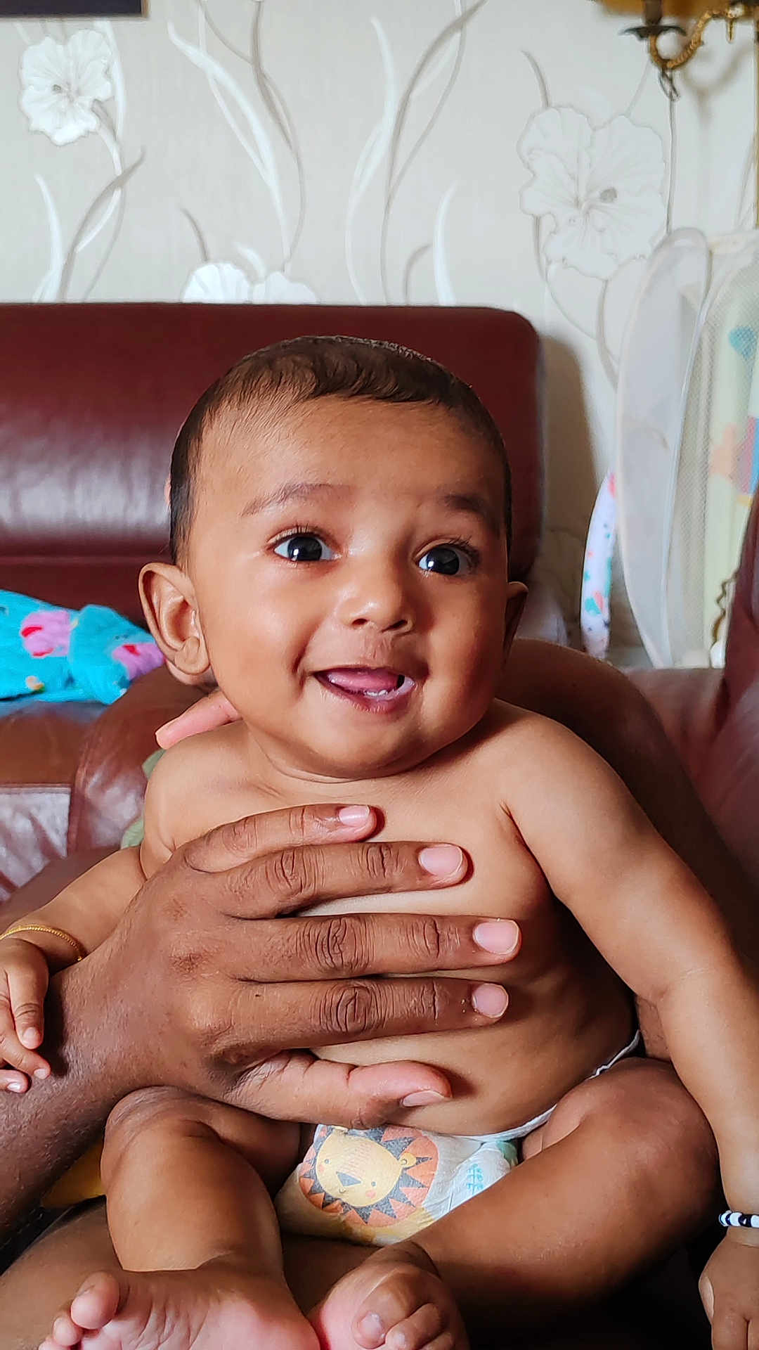 Evynn participe au concours pour gagner de l'argent avec cette photo : baby, child, smiling, hands, diaper, lion, couch, leather, wallpaper, floral, indoor, person, cute, happy, skin, infant, seated, expression, family, comfort