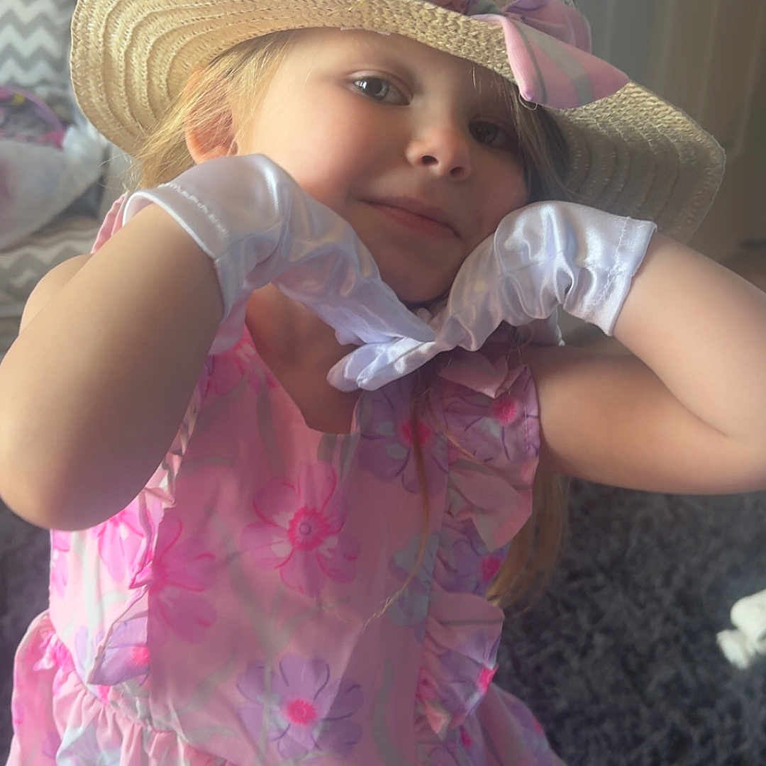 Kaycee joined the competition — help win amazing prizes! child, girl, hat, gloves, dress, pink, flower_pattern, indoor, carpet, door, playful, portrait, smile, young, fashion, cute, person, childhood, accessory, room