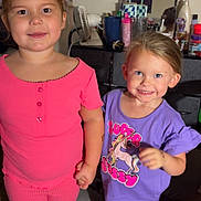 Kaycee is registered to the contest to win money with this photo: child, children, smiling, indoors, carpet, dresser, clothing, pink_outfit, purple_outfit, holding_hands, person, happy, footwear, toy, room, mirror, fan, bottle, casual, portrait