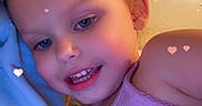 Kaycee is registered to the contest to win money with this photo: child, smiling, face, tank_top, blue_clothing, heart_effects, indoor, blond_hair, close_up, portrait, cute, happy, skin, young, person, casual, warm_lighting, stains, affectionate, snuggling