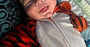 Malakai joined the competition — help win amazing prizes! baby, child, smiling, tiger_onesie, costume, tongue_out, pillow, blanket, bed, happy, infant, face, clothing, cute, person, portrait, indoors, cozy, young, sleepwear