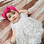 baby, infant, dress, headband, pink, white, floral, blanket, pattern, lying_down, cute, child, portrait, skin, hand, arm, legs, indoors, soft_texture, adorable