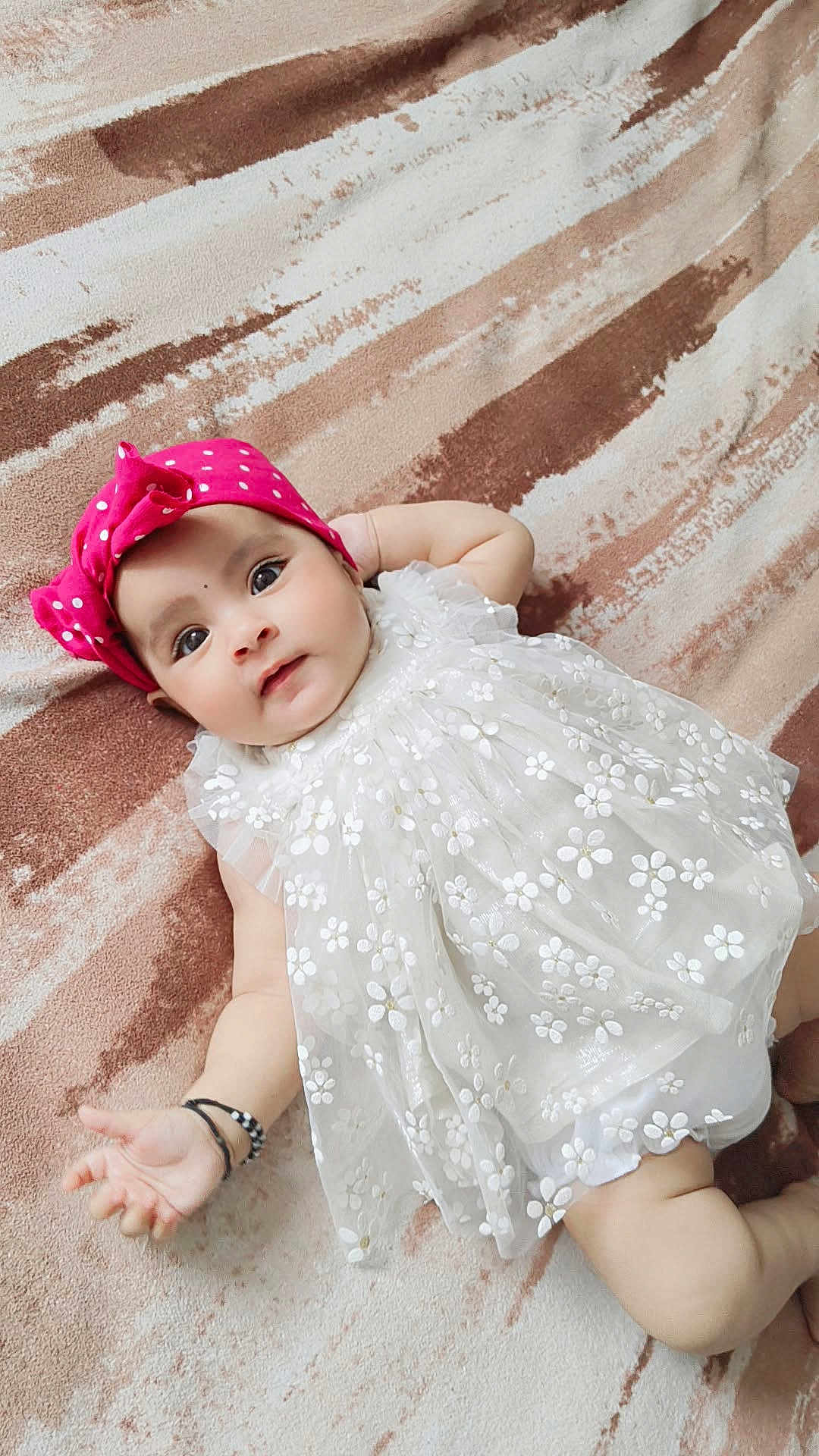 Ajooni is registered to the contest to win money with this photo: baby, infant, dress, headband, pink, white, floral, blanket, pattern, lying_down, cute, child, portrait, skin, hand, arm, legs, indoors, soft_texture, adorable