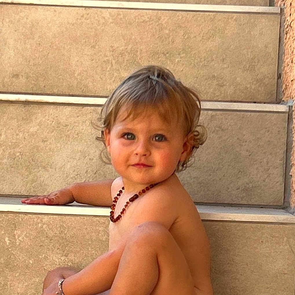 Juliette a rejoint le concours — aidez-le/la à gagner de superbes lots ! baby, bare_skin, bright_eyes, candid, casual, child, curly_hair, cute, innocent, natural_light, necklace, outdoor, person, portrait, relaxed, sitting, smile, stairs, toddler, young_child