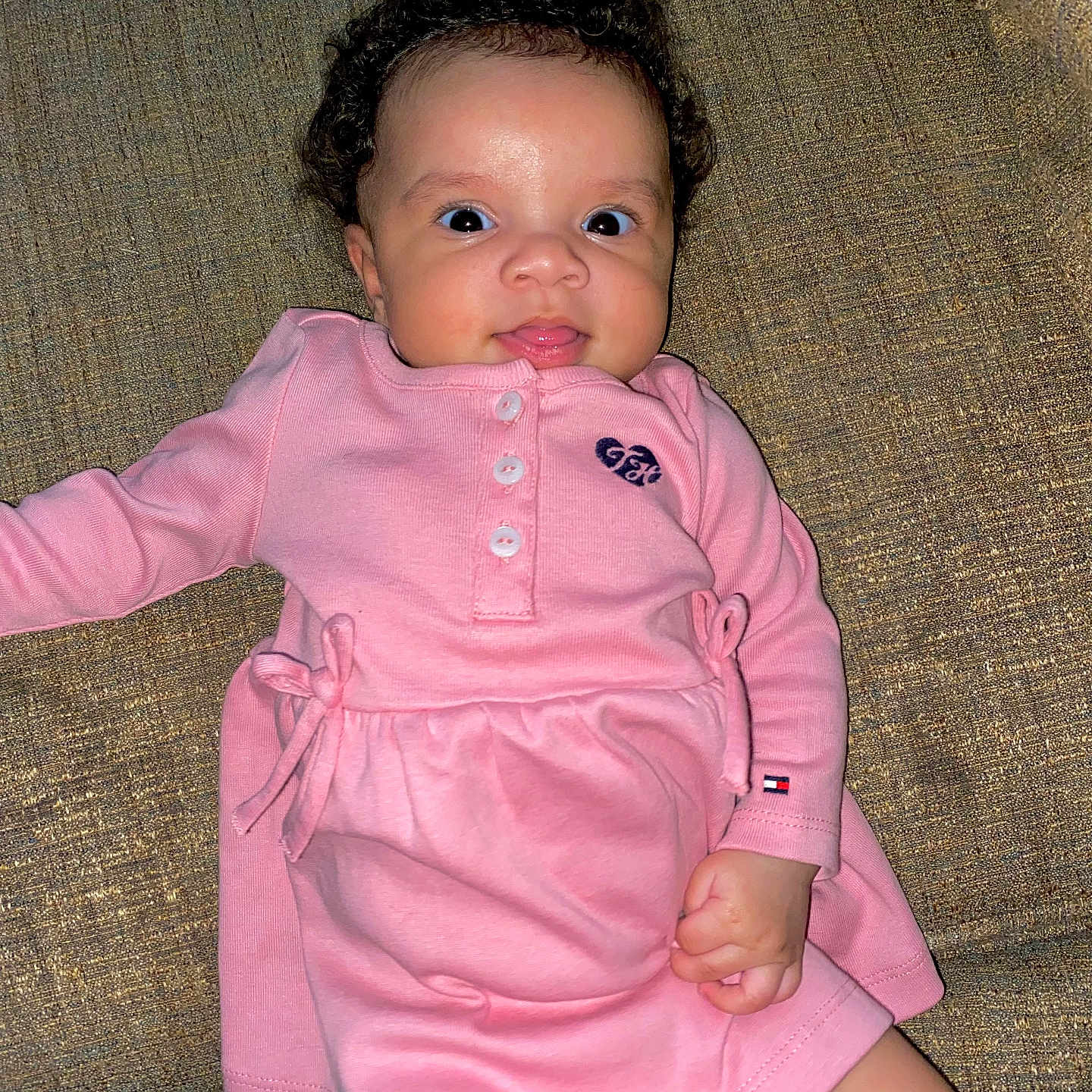 Ariella is registered to the contest to win money with this photo: baby, bodypart, clothing, couch, dress, face, finger, furniture, hand, head, homedecor, knitwear, longsleeve, pants, person, photography, portrait, sitting, sleeve, sweater