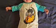 Nélia a rejoint le concours — aidez-le/la à gagner de superbes lots ! baby, child, smiling, onesie, cartoon_character, bed, blanket, clothing, infant, person, portrait, happy, lying_down, socks, cute, indoors, young_child, sleepwear, baby_clothes, face