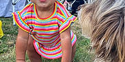 Anaiah joined the competition — help win amazing prizes! toddler, child, smiling, dog, pet, outdoor, grass, brick_wall, colorful_clothing, playtime, happy, curly_hair, yellow_hair_ties, canopy_frame, nature, cute, person, animal, face, daytime