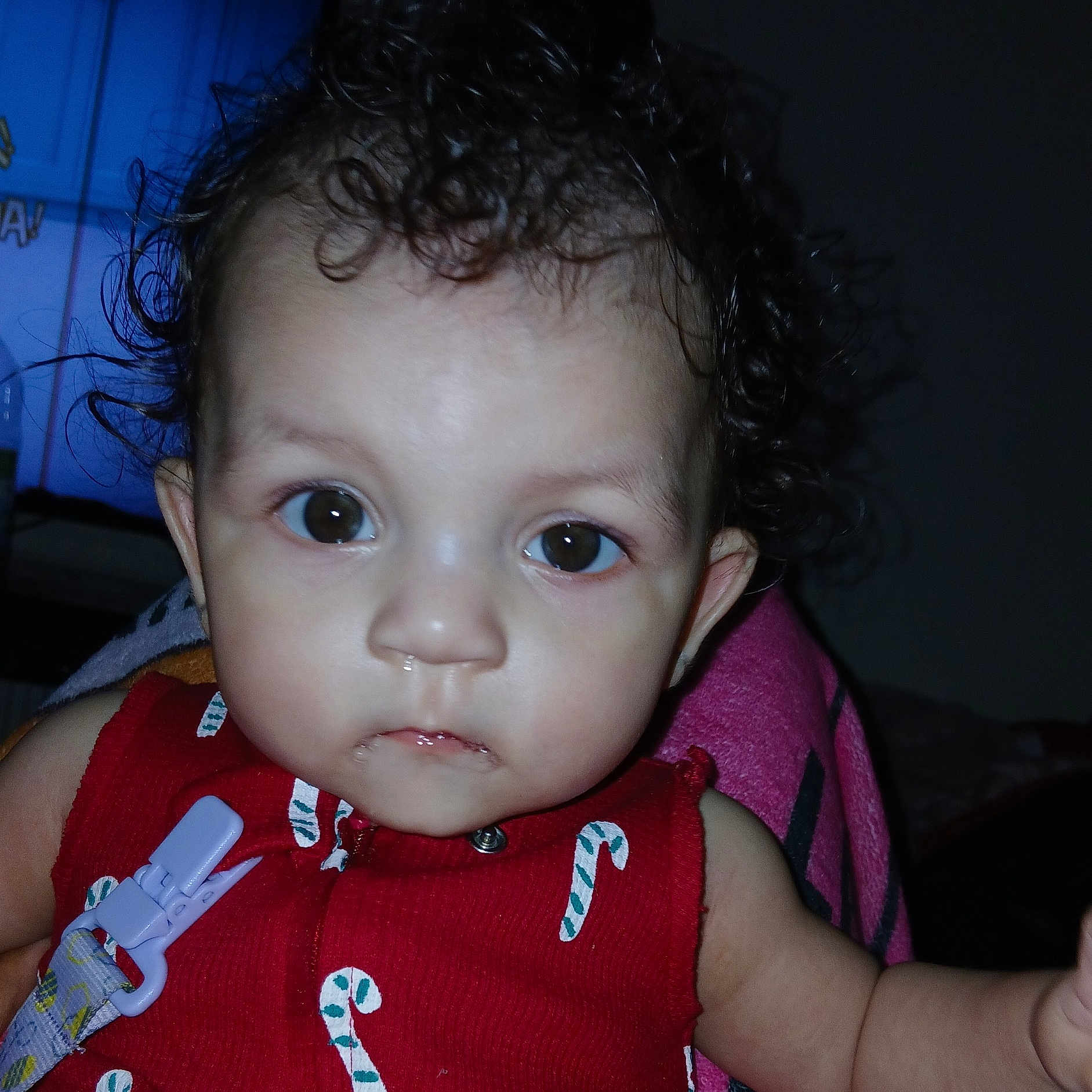 Passion is registered to the contest to win money with this photo: baby, brown_eyes, candy_cane_pattern, child, close_up, curly_hair, cute, drool, expression, face, head, indoors, infant, looking, person, portrait, red_clothing, skin, wearing, young