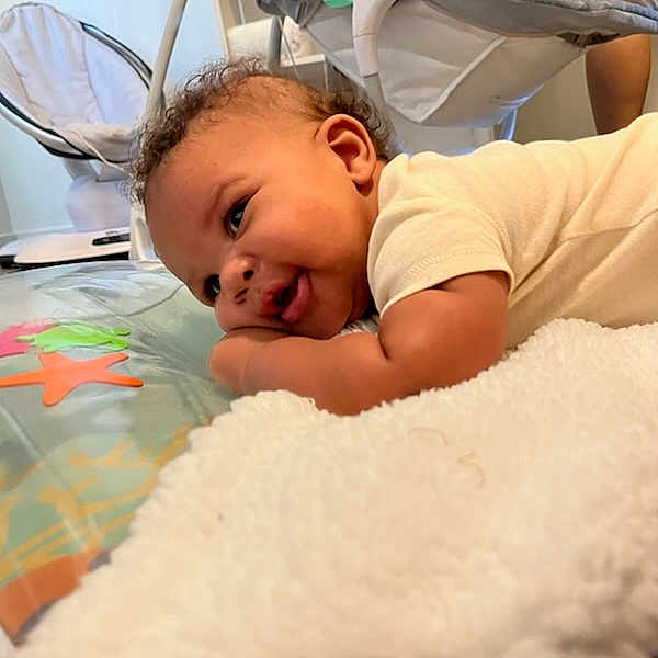 Karter joined the competition — help win amazing prizes! baby, infant, child, portrait, lying_down, tummy_time, smiling, curious, face, eyes, nursery, blanket, play_mat, baby_swing, indoor, home, cozy, daylight, clothing, parent