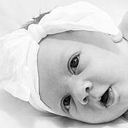 Maisie joined the competition — help win amazing prizes! baby, infant, headband, bow, closeup, face, eyes, mouth, skin, newborn, portrait, lying_down, white, soft, expression, cute, child, young, headwear, monochrome