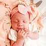 baby, sleeping, infant, pink, headband, bow, blanket, floral, soft, cozy, cute, peaceful, newborn, white_clothing, hands, portrait, closeup, indoors, child, adorable