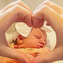 Maisie is registered to the contest to win money with this photo: baby, sleeping, hands, heart_shape, blanket, floral_pattern, infant, closeup, soft_lighting, headwear, peaceful, cute, newborn, skin, person, portrait, love, tenderness, hand_gesture, cozy