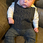Cillian joined the competition — help win amazing prizes! baby, child, infant, face, hat, clothing, vest, pants, barefoot, couch, leather, sitting, indoor, portrait, cute, serious, young, person, fashion, home