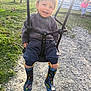Solan a rejoint le concours — aidez-le/la à gagner de superbes lots ! toddler, child, swing, smiling, outdoor, playground, grass, boots, rain_boots, gray_sweater, happy, daylight, park, person, clothing, footwear, nature, recreation, fun, joy