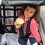 Djodie a rejoint le concours — aidez-le/la à gagner de superbes lots ! child, curly_hair, stroller, pink_jacket, paper_cup, snacks, blanket, casual_clothing, footwear, smile, playful, seatbelt, outdoor, toy, comfort, relaxing, young_child, sitting, happy, portrait